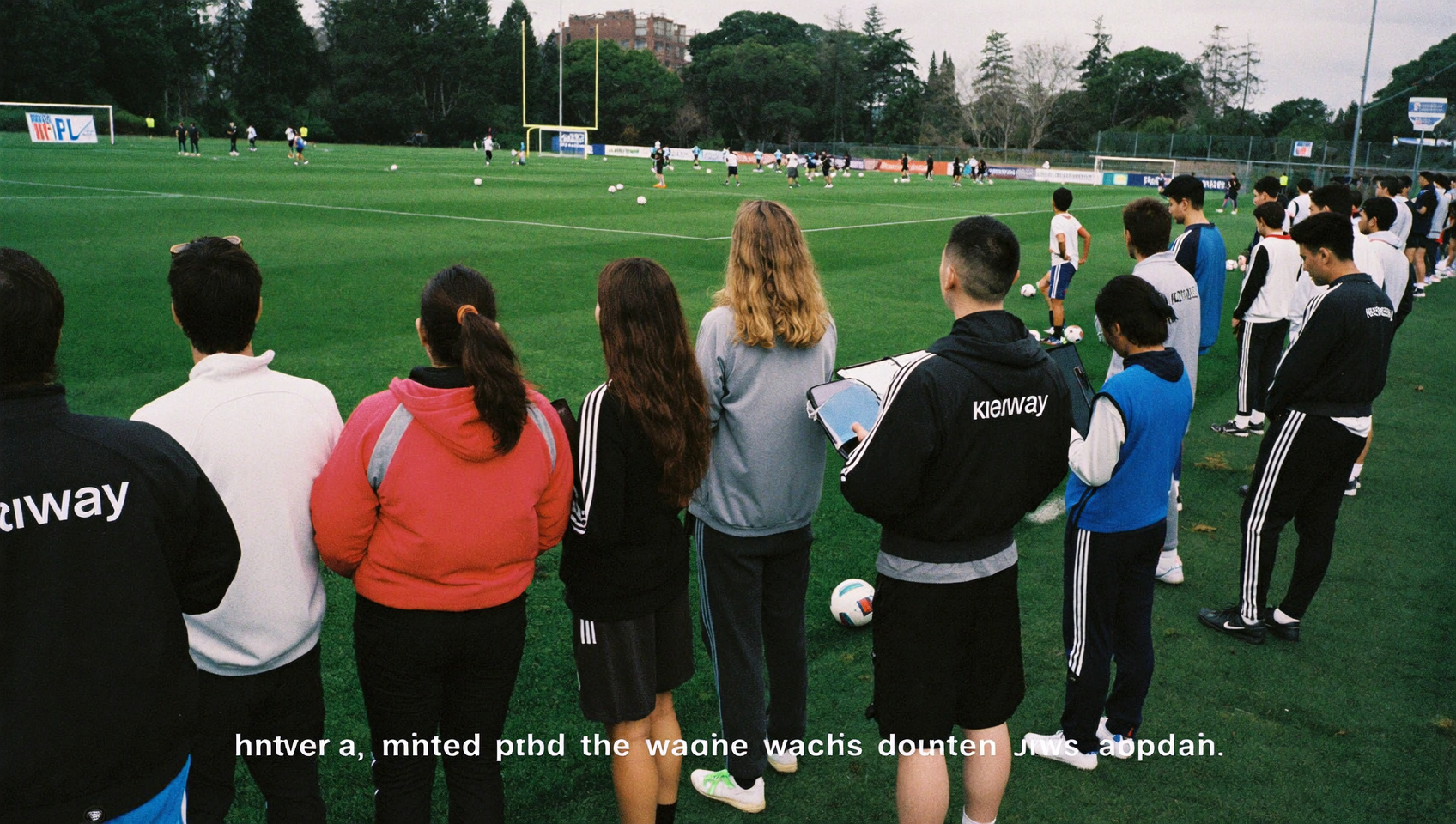 Grupo de scouts y entrenadores observando jugadores en un entrenamiento de fútbol
